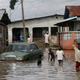 People walk along flooded streets after a heavy downpour in Lagos